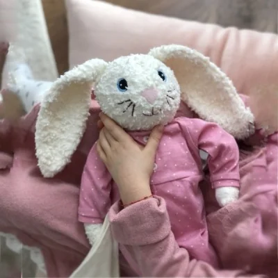 Enfant jouant avec Peluche doudou lapin Hoopsi rose signée Hugzzeee Friends Enfant jouant avec Peluche doudou lapin Hoopsi rose signée Hugzzeee Friends