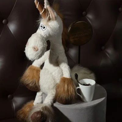 Peluche licorne "Uni Que" signée Sigikid buvant le café