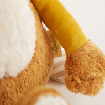 Peluche lion Patchwork en coton bio, Green signée Sigikid, gros plan sur un bras Peluche lion Patchwork en coton bio, Green signée Sigikid, gros plan sur un bras