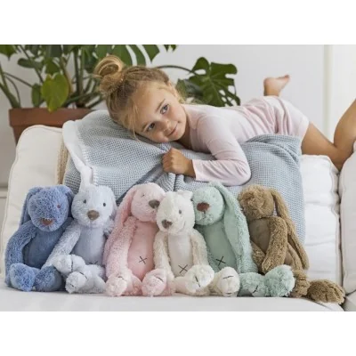Jeune fille avec groupe de peluches Lapin Richie de différentes couleurs signées Happy Horse