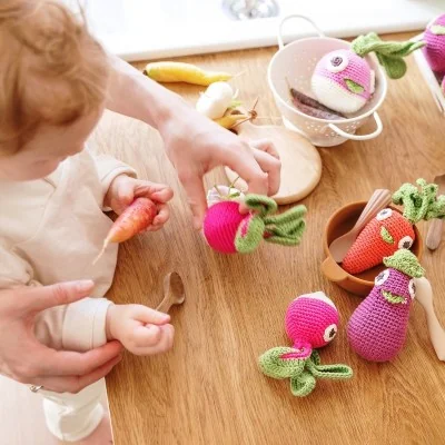 Enfant jouant avec hochets en coton bio signés MyuM Enfant jouant avec hochets en coton bio signés MyuM