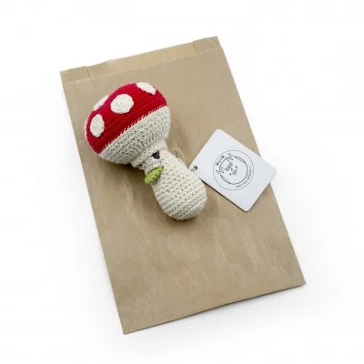Meredith l'Amanite - hochet pour bébé en coton bio de la collection Veggy Toys de la marque MyuM, posé sur une feuille de papier Meredith l'Amanite - hochet pour bébé en coton bio de la collection Veggy Toys de la marque MyuM, posé sur une feuille de papier