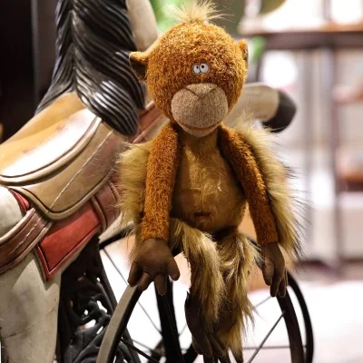 Peluche singe "Mon Key" de la collection BEASTS de la marque Sigikid, devant un manège Peluche singe "Mon Key" de la collection BEASTS de la marque Sigikid, devant un manège