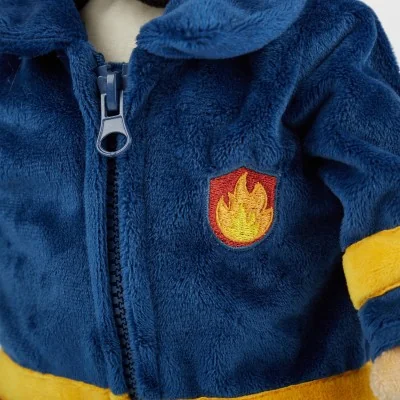 Poupée d'apprentissage pompier signée Sigikid, gros plan sur l'emblème des pompiers Poupée d'apprentissage pompier signée Sigikid, gros plan sur l'emblème des pompiers