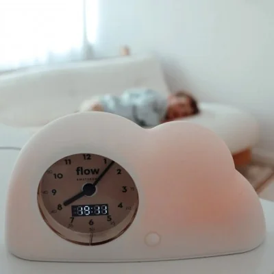 Réveil Éducatif Nuage (Cloud sleep trainer) de la marque Flow Amsterdam, allumé en orange Réveil Éducatif Nuage (Cloud sleep trainer) de la marque Flow Amsterdam, allumé en orange