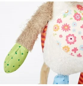 Doudou vache Patchwork Sweety signée Sigikid, gros plan sur un bras