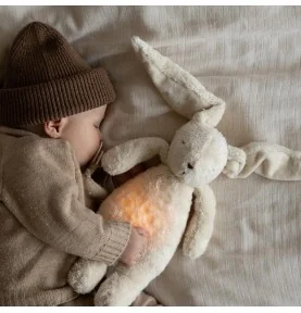 Bébé dormant avec Peluche veilleuse lapin nature bio - sable signée Moonie Bébé dormant avec Peluche veilleuse lapin nature bio - sable signée Moonie
