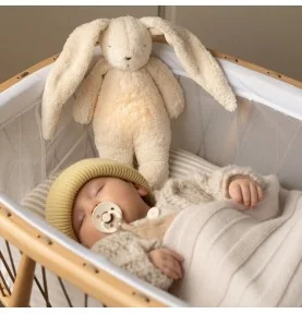 Bébé dormant avec Peluche veilleuse lapin nature bio - sable signée Moonie Bébé dormant avec Peluche veilleuse lapin nature bio - sable signée Moonie
